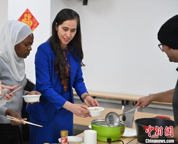 今年春节，加汉(着蓝色衣服者)和留学生一起包饺子、煮饺子。　李亚龙 摄